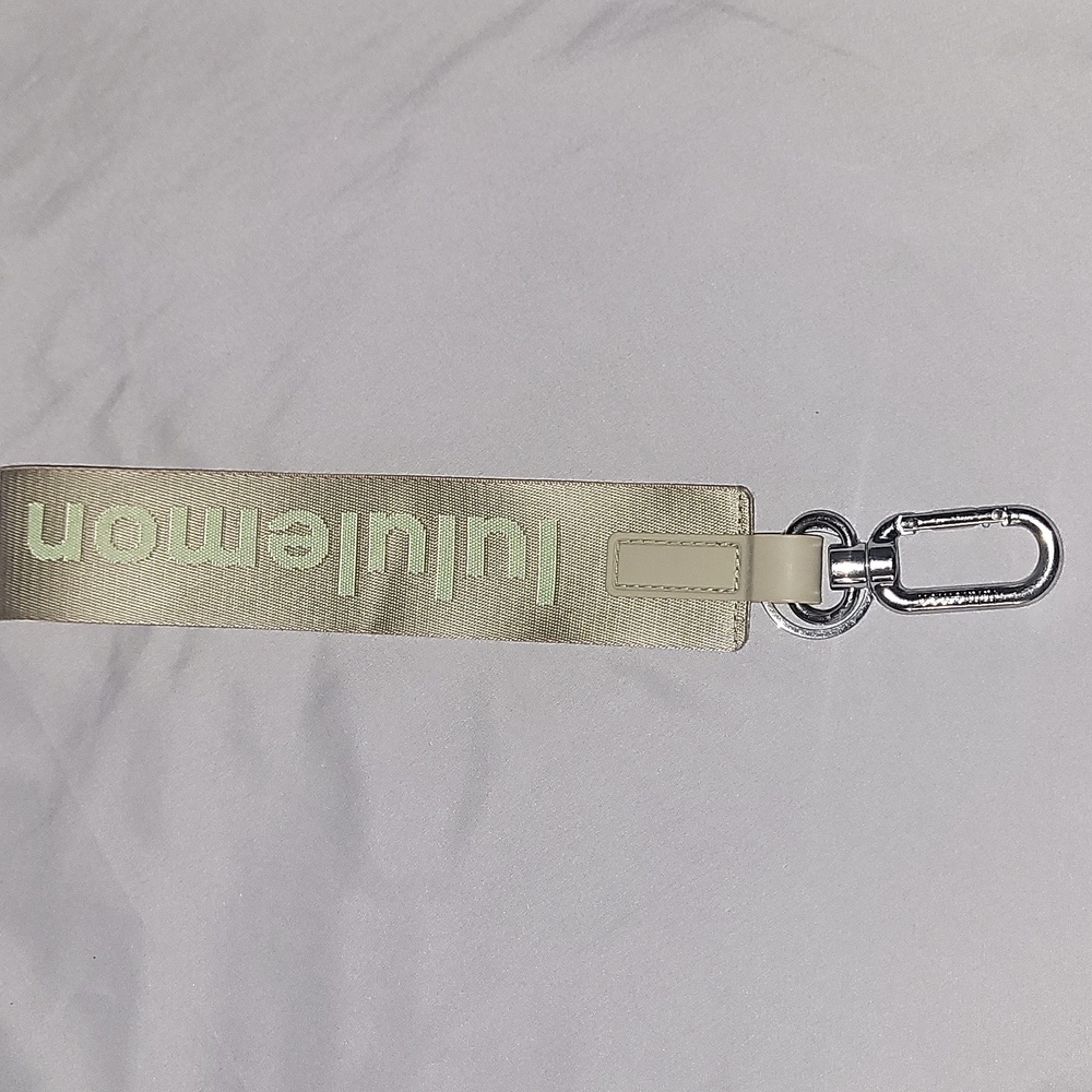 lululemon keychain, color tan and lime greenish color